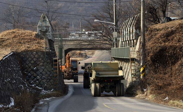 파주시 파평면 두포리의 도로낙석 구간에서 군용 트럭과 굴삭기가 교차 통행을 하고 있다. 기존에 설치된 대전차방호벽으로 인해 도로 확장이 기형적으로 이루어진 경우다.