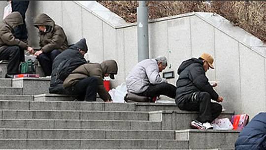 노숙인 한 무리가 지하철 서울역사 계단에서 식사를 하고 있다.