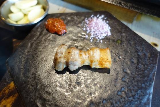 여주인이 익은 고기 한 점을 앞접시 대신 놓은 돌판에 올려주며 아무것도 찍지 말고 먹어보라고 권했다. 먹어 보니 간이 모자라지 않았다.