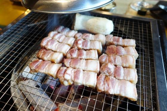 두툼한 고기 양면을 노릇하게 구운 다음 한입 크기로 잘라 나란히 펼쳐놓고 속살을 익히고 있다.