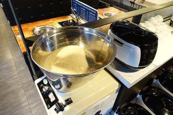 정미기에서 현미를 9분도 쌀로 도정하고 있다. 아래 오른쪽 손잡이로 쌀을 깎는 정도를 조절할 수 있다.