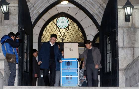 지난해 검찰이 비선실세 최순실의 딸 정유라 부정입학과 관련 22일 이화여대 총장실과 입학처 등에 대한 압수수색에 나섰다. 검찰 관계자들이 본관 총장실에서 압수한 물품을 차량으로 옮기고 있다. [중앙포토]