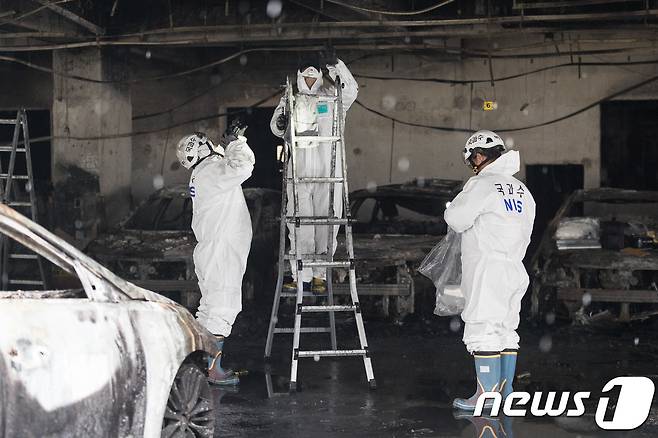 국립과학수사연구원 직원들과 경찰 과학수사대가 24일 제천 스포츠센터 화재 현장 1층 주차장 발화지점 부근에서 현장 감식을 하고 있다. 2017.12.24/뉴스1 © News1 유승관 기자