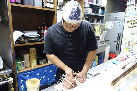 돼지 등심을 꼬치에 꿰는 김상호씨.