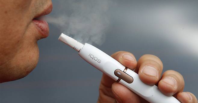 궐련형 전자담배인 아이코스를 흡연하고 있는 남성. 대한금연학회는 이러한 궐련형 전자담배의 명칭 자체를 바꿔야 한다고 권고했다. [프리랜서 공정식]