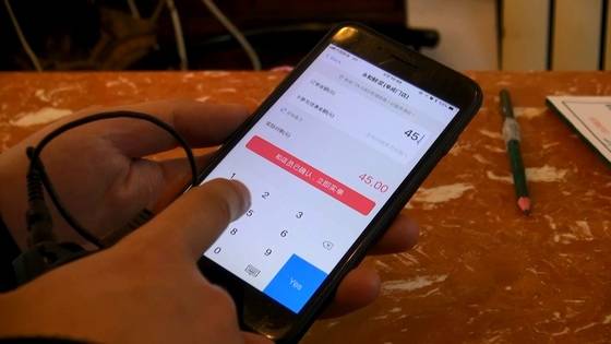 문재인 대통령이 방문한 서민식당 융허셴장 테이블에 붙어 있는 알리바바의 모바일 결제 서비스 즈푸바오 QR 코드를 스캔한 뒤 결제 금액을 입력하고 있다. 이곳도 이미 손님의 절반 이상이 현금을 사용하지 않고 있었다. [사진=선르주 JTBC 촬영기자]