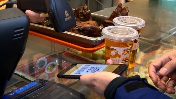 베이징 시청구 칭펑만두 웨탄점에서 칭펑 배즙 음료를 주문한 뒤 알리바바 즈푸바오 앱의 바코드로 결제하는 모습. [사진=선르주 JTBC 촬영기자]