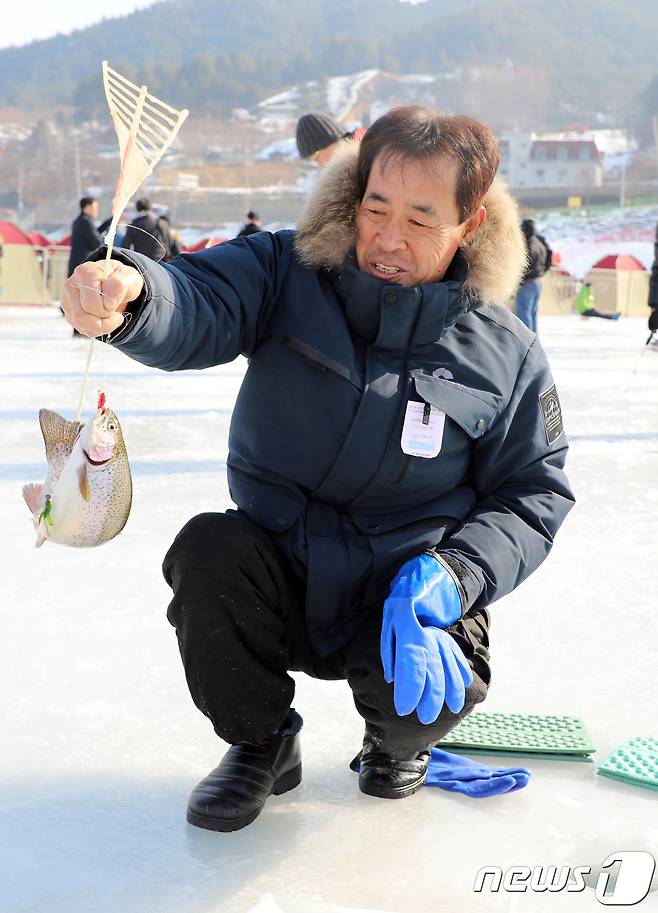 5일 강원 홍천군 홍천강변에서 열린 제6회 홍천강 인삼송어 축제에서 관광객이 송어를 낚아 기뻐하고 있다. 이번 축제는 오는 21일까지 계속되며 주요 프로그램은 얼음낚시, 가족텐트낚시, 인삼송어 맨손잡기 등이다. 2018.1.5/뉴스1 © News1 하중천 기자