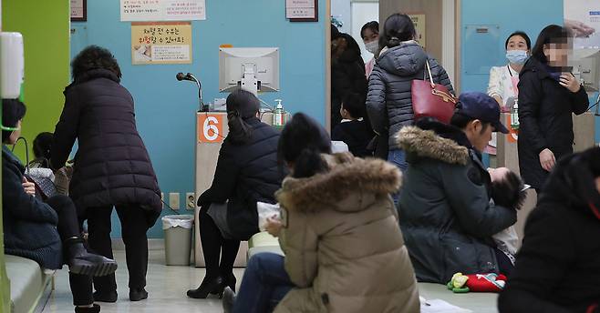 서울의 한 병원 소아청소년과 대기실에서 어린이와 보호자들이 독감 진료 순서를 기다리고 있다. [연합뉴스]