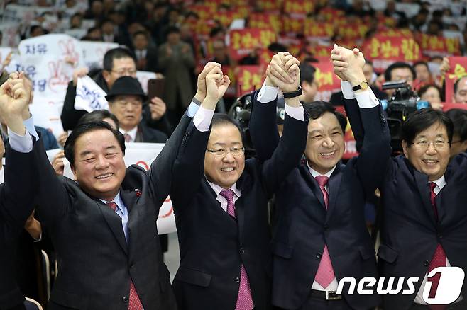 홍준표 자유한국당 대표가 15일 오후 울산상공회의소에서 열린 '자유한국당 울산시당 신년인사회'에 참석해 정갑윤 의원과 김기현 울산시장, 강길부 의원과 함께 손을 들어 인사하고 있다. 2018.1.15/뉴스1  © News1 이윤기 기자