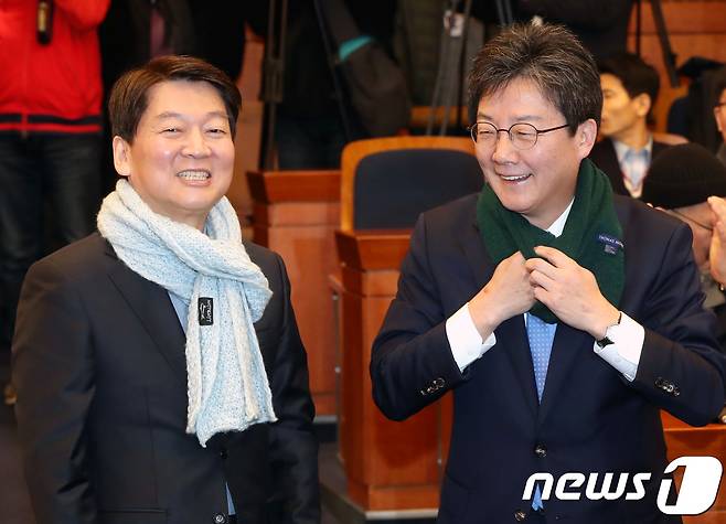 안철수 국민의당 대표와 유승민 바른정당 대표가 19일 오전 서울 여의도 국회 헌정기념관에서 열린 국민의당 청년당원과의 소통의 장 '청년이 미래다!' 행사에서 상대당 정당색 목도리를 매고 있다.  2018.1.19/뉴스1 © News1 박정호 기자