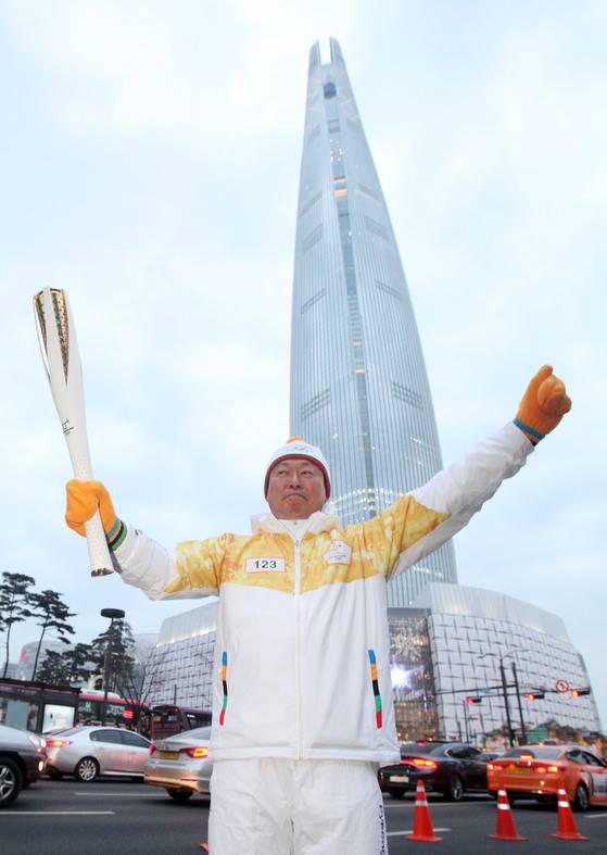 지난 14일 롯데월드타워 인근에서 신동빈 롯데그룹 회장이 성화봉송에 앞서 포즈를 취했다. 신격호 총괄회장은 롯데월드타워 시그니엘레지던스로 집무실을 옮겼는데 신동빈 회장은 아직 이사오지 않았다.