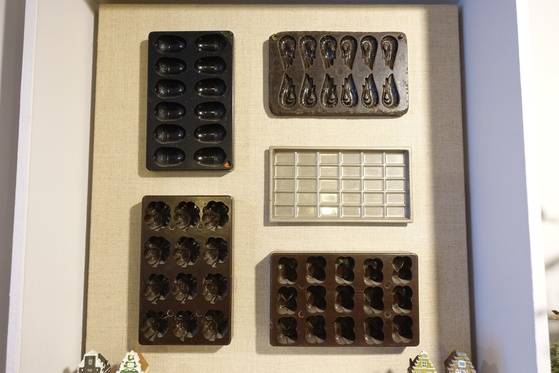 초콜릿 모형을 찍는 틀(거푸집)을 모아 액자를 만들고 카페 벽에 걸었다. 고 대표의 조형감각이 엿보이는 작품이다.