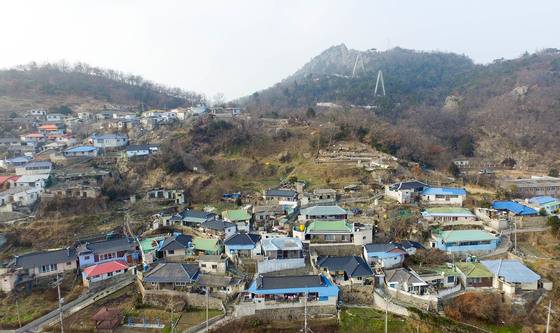 ‘연희네슈퍼’가 자리한 전남 목포시 서산동 정상에서 바라본 유달산 모습. 산 정상부에서 고하도를 잇는 해상케이블카 설치 작업이 이뤄지고 있다. 프리랜서 장정필
