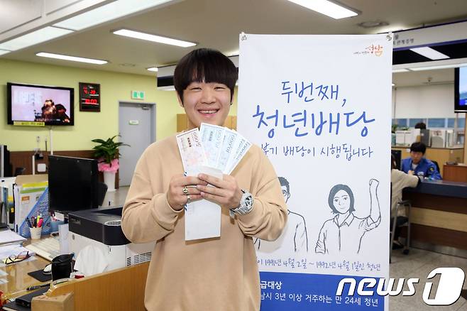 성남사랑상품권으로 청년배당 받은 청년이 활짝 웃고 있다.(성남시 제공)© News1