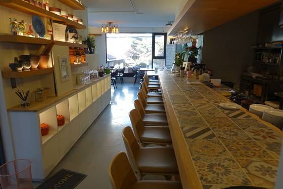 ‘쿤쏨차이’ 내부. 카운터 테이블 12석, 홀 20석 등 32석을 갖췄다. 카운터 테이블 오른쪽이 공개 주방이다.