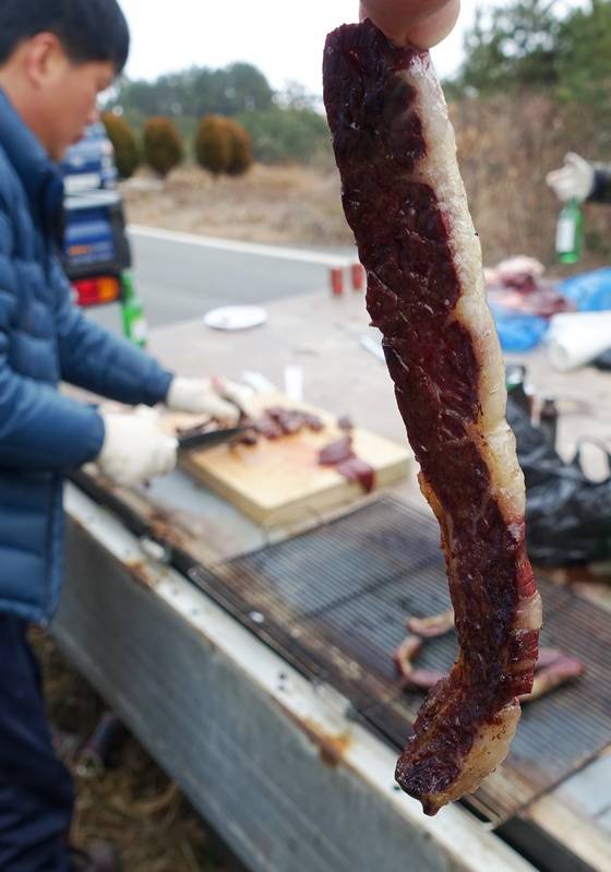 즉석에서 나무들을 주워 모아 일군 화톳불에 잘 구워진 고기.
