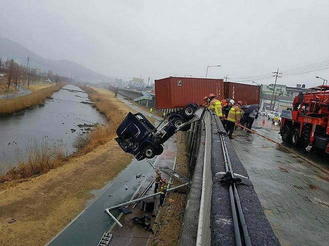 부산의 한 도로에서 보행자를 피하던 트레일러가 미끄러져 5m 아래로 추락했다. 운전자가 타고 있던 차량 앞면은 컨테이너가 도로에 걸려 다행히 바닥에 닿기 직전 멈췄다. (사진=부산경찰청 제공)