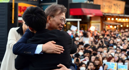 문재인 대통령이 더불어민주당 대선 후보 시절 지난해 5월6일 서울 마포구 홍대입구역 인근에서 열린 '투표 참여 릴레이 버스킹 vote0509'에서 사전 투표율 25% 달성을 축하하는 프리허그 이벤트를 하고 있는 모습. 연합뉴스