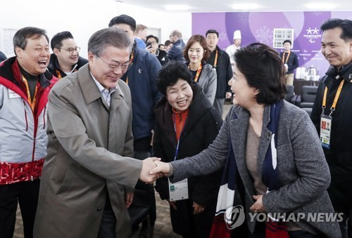 문재인 대통령이 14일 강원도 평창 바이애슬론센터에서 열린 2018 평창패럴림픽 크로스컨트리 예선 경기를 관람하기 앞서 먼저 도착한 김정숙 여사를 만나 반갑게 악수하고 있다. [청와대 제공=연합뉴스]