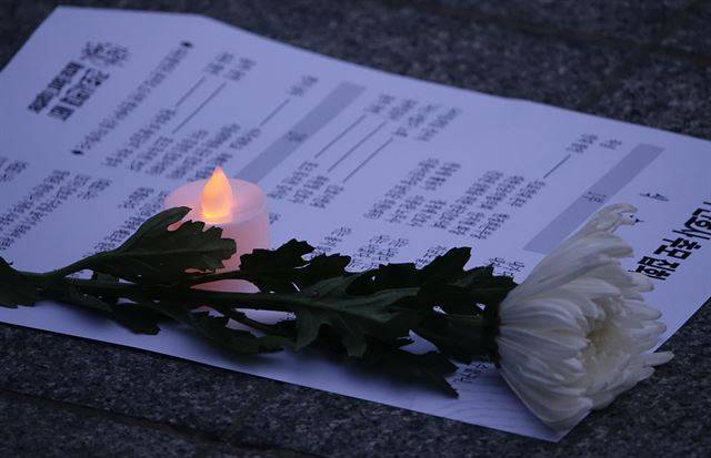 3일 저녁 서울 광화문역 인근에서 열린 '고 박선욱 간호사 추모집회'에 고인을 추모하는 국화와 촛불램프가 놓여 있다. 연합뉴스