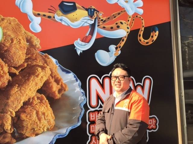 ‘알엔디’ 연구소 최계호 차장이 ‘치토스 치킨’ 포스터 앞에서 포즈를 취하고 있다. 유선주 기자