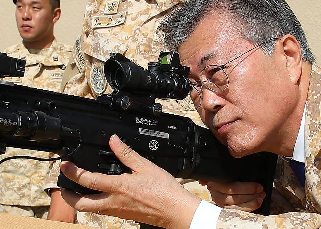 아랍에미리트(UAE)를 공식 방문 중인 문재인 대통령이 27일 오전(현지시간) 아부다비에 주둔하고 있는 아크 부대를 방문해 부대에서 운용중인 소총을 조준해 보고 있다. [연합뉴스]