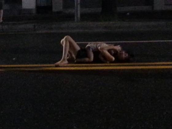 지난달 22일 아동학대 혐의로 검찰에 송치된 A목사가 2014년 6월 전북 전주시 중앙동 4차선 도로 중앙선 부근에서 자신이 입양한 남자아이(당시 3세)를 품에 안은 채 드러누워 괴성을 지르고 있다. [사진 동영상 캡처]