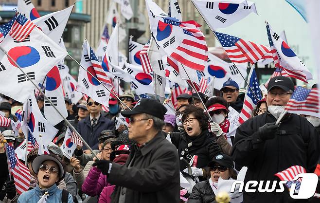 박근혜 전 대통령 지지자들이 7일 서울 덕수궁 대한문 앞에서 열린 태극기시민혁명운동본부 주최 태극기 혁명 국민대회에서 태극기와 성조기를 흔들며 박 전 대통령의 1심 선고 판결에 대해 규탄하고 있다. 2018.4.7/뉴스1 © News1 유승관 기자