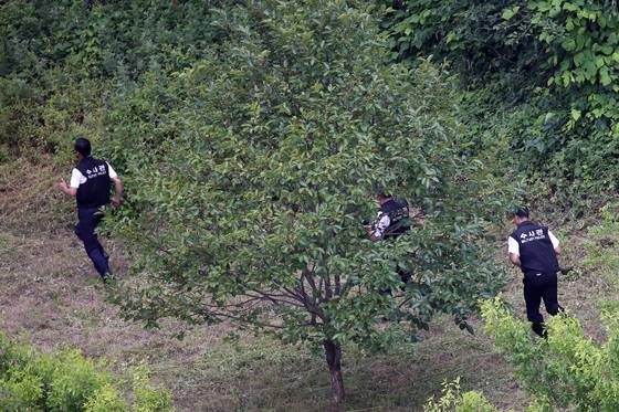 23일 강원도 고성군 현내면 마차진리 야산에서 육군 22사단 GOP(일반전초) 총기 난사 탈영병 임모 병장이 군병력과 대치하다 자살을 시도한 가운데 총소리를 들은 군 수사관들이 급히 현장으로 달려가고 있다. [뉴스1]