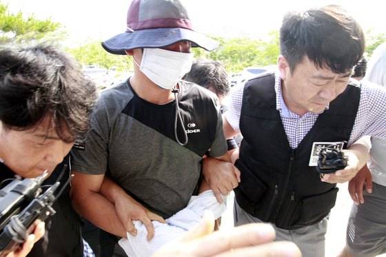 지난해 7월 5일 경남 합천군 대병면 황매산 터널 인근에서 엽총 인질극을 벌인 김모(42)씨가 자수 의사를 밝혀 경찰이 긴급체포하여 경찰서로 연행하는 모습 [뉴스1]