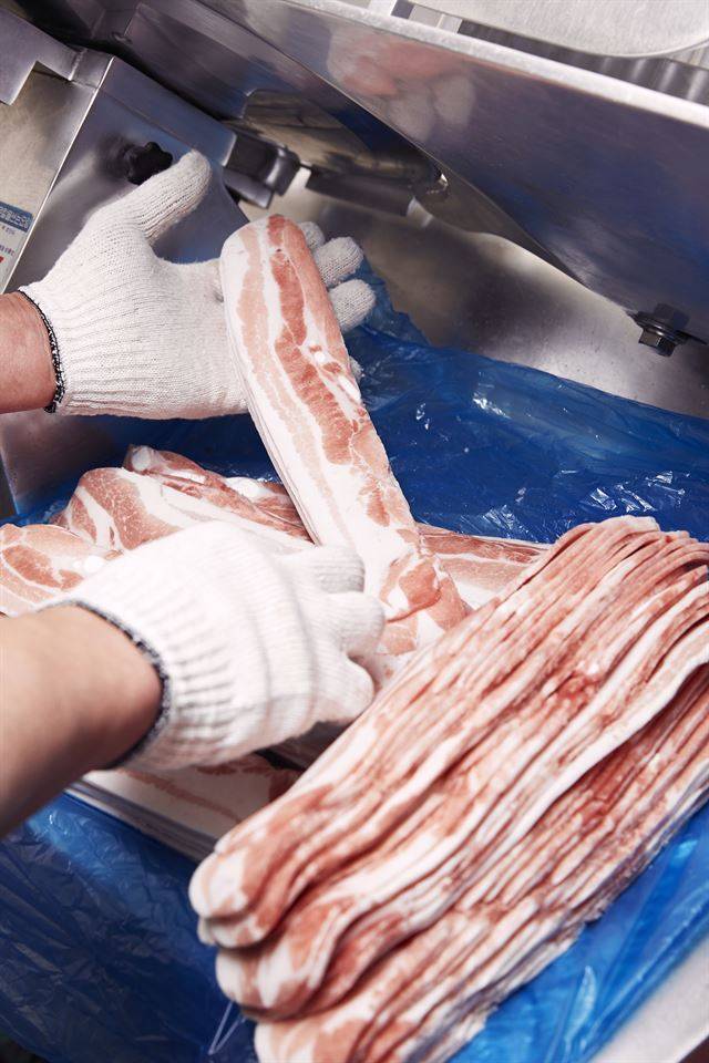 서울 합정동 행진에서 그날 사용할 고기를 썰고 있다. 영하 3도에서 해동시킨 후 육절기를 사용해 일정한 두께로 얇게 잘라낸다. 이가은 사진작가