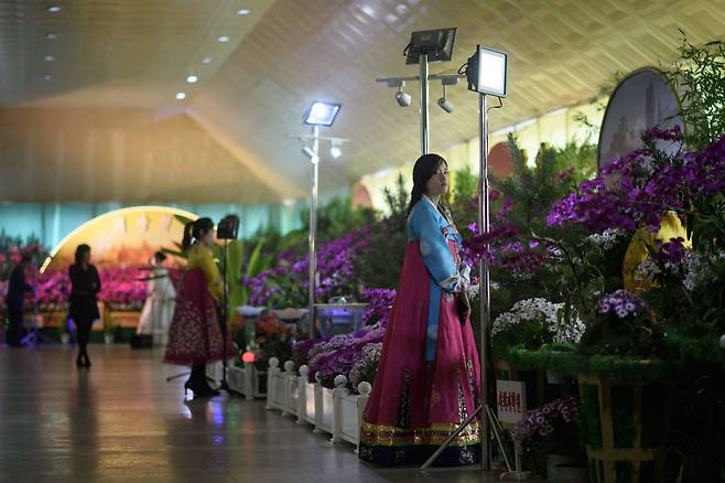 '김일성화축전' 열린 김일성화김정일화전시관에 전시 도우미가 한국을 차려입고 있다. [AFP=연합뉴스]