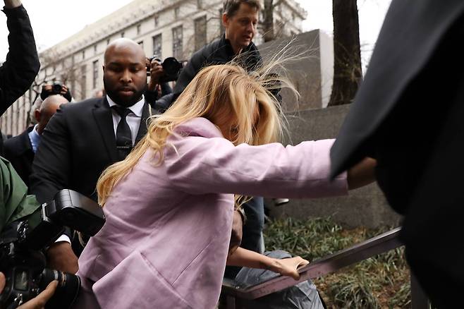 법원에 출석하던 스토미 대니얼스가 둘러쌓인 취재진에 떠밀려 넘어지려하자 난간을 붙잡고 있다. [AFP=연합뉴스]