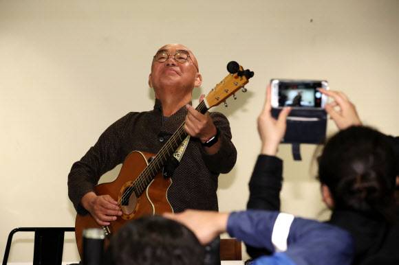 다시 음악 너무 설레 - 가수 이장희가 17일 열린 기자간담회에서 자신의 노래 ‘내 나이 육십하고 하나일 때’를 기타를 치며 부르고 있다. 일흔을 넘긴 그는 다음달 울릉도 자택 부지에 개관하는 ‘울릉천국 아트센터’ 무대에 일주일에 세 번씩 오르며 음악 활동을 재개한다. 연합뉴스