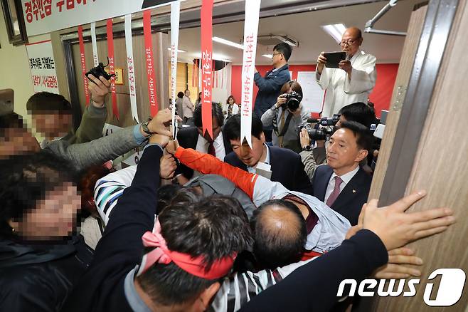 6·13 지방선거 자유한국당 후보 공천에서 탈락한 최양식 경주시장 지지자를 비롯한 경산, 의성 등 경북지역 주민들이 18일 오전 경북도당을 방문해 공천 결과를 받아들일 수 없다며 김석기 도당위원장(오른쪽)에게 거세게 항의하며 위원장실 입구를 막고 있다. 2018.4.18/뉴스1 © News1 공정식 기자