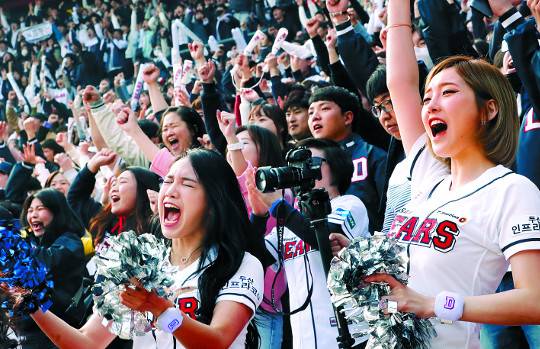 야구팬과 치어리더들이 2018 신한은행 MY CAR KBO리그 개막일인 3월 24일 서울 잠실구장에서 열린 두산 베어스와 삼성 라이온즈의 경기에서 열띤 응원을 펼치고 있다. 뉴시스