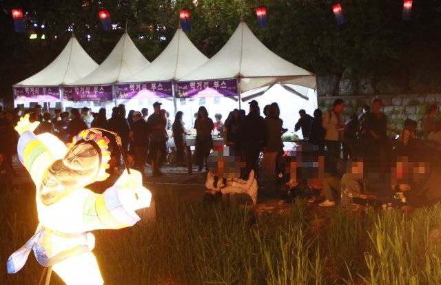 1일 오후 서울 노원구 중계동 당현천 일대에서 열리는 ‘노원 등축제’ 먹거리 부스 주변으로 술판이 벌이지고 있다.