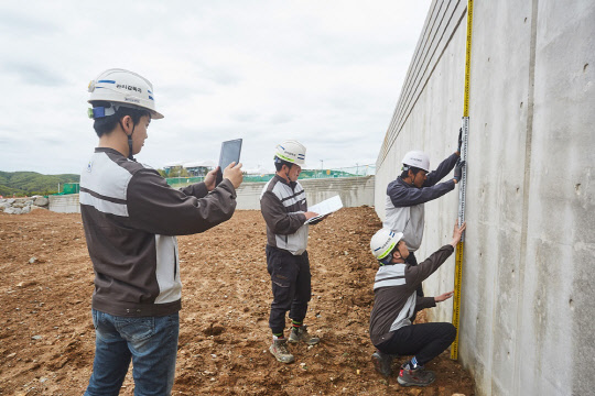 용인테크노밸리 조성공사현장에서 한화건설 직원들이 현장검측 모바일 앱을 통해 시공내역을 점검하고 있다.<한화건설 제공>