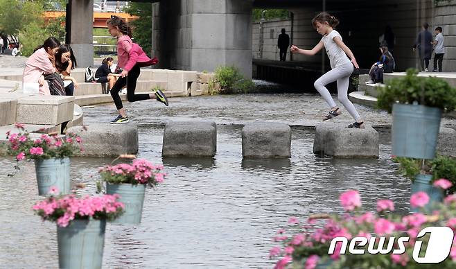 완연한 봄 날씨를 보인 26일 오후 서울 청계천에서 아이들이 가벼운 차림으로 돌다리를 건너고 있다. 2018.4.26/뉴스1 © News1 박지수 기자