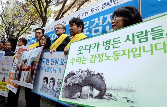 지난 2014년 서울 중구 명동 예술극장 앞에서 민주노총 서비스연맹 주최로 열린 감정노동자 보호 대국민 캠페인에서 참석자들이 피켓을 들고 '감정노동자보호법 국회 통과'를 촉구하고 있다. 한국일보 자료사진