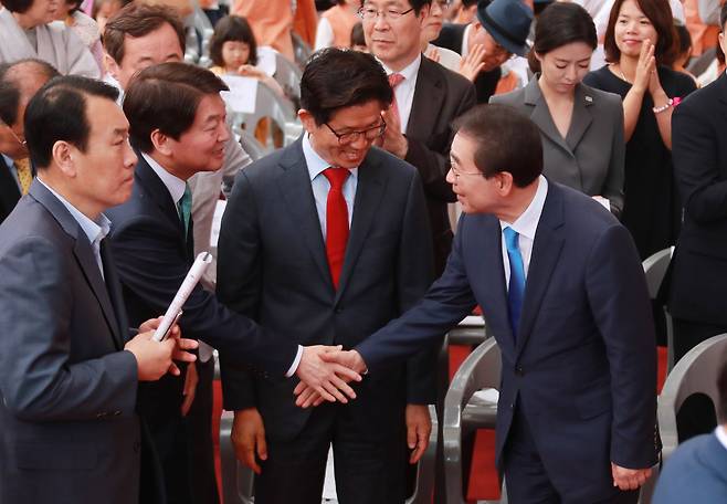 22일 서울 종로구 견지동 조계사에서 열린 불기 2562년 부처님 오신날 봉축법요식에서 안철수 바른미래당 서울시장 예비후보, 김문수 자유한국당 예비후보, 박원순 더불어민주당 서울시장 예비후보가 악수를 나누고 있다. 2018.5.22/뉴스1