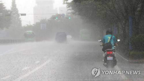 소나기 내리는 서울 (서울=연합뉴스) 하사헌 기자 = 6일 오전 서울 동작구 대방동에서 세차게 내리는 소나기 속에  한 오토바이가 운행하고 있다. 2017.8.6      toadboy@yna.co.kr