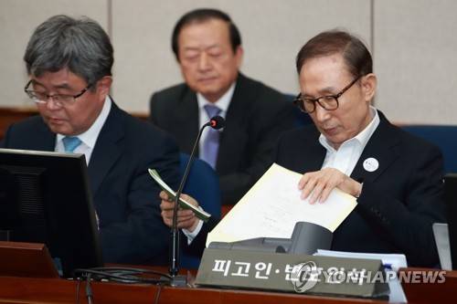 자료 보는 MB (서울=연합뉴스) 한상균 기자 = 뇌물수수와 다스 횡령 등 혐의로 구속기소 된 이명박 전 대통령이 23일 오후 서울중앙지법에서 열린 첫 공판에 출석하고 있다. 2018.5.23      xyz@yna.co.kr