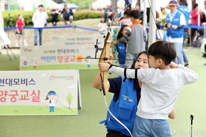 정선옥 전 울산남구청 양궁팀 선수가 '드림무브 어린이 양궁교실'에 참가한 어린이를 지도하고 있다./사진제공=현대모비스