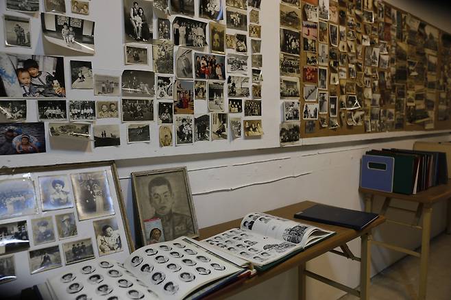 추억 속의 사진관 풍경. 까까머리 남학생과 단발머리 여학생들의 흑백사진이 빼곡한 졸업앨범이 펼쳐져 있다. 다른 벽면에는 바지를 벗겨놓고 찍은 돌사진이 붙어 있다.  ⓒ이돈삼