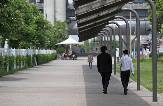 서울 뚝섬유원지를 찾은 시민들이 햇볕을 피해 태양광 발전 그늘막 아래를 지나고 있다. [연합뉴스]