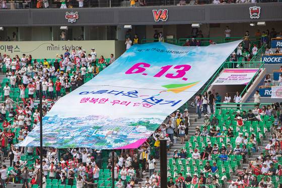 지난달 27일 오후 인천 SK행복드림구장에서 열린 프로야구 인천 SK 와이번스와 대전 한화 이글스의 경기에서 인천선거관리위원회 관계자들과 관중이 함께 6·13 지방선거 투표 참여를 홍보하고 있다. [연합뉴스]