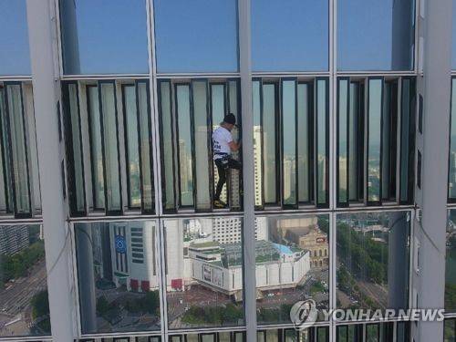 프랑스 유명 암벽등반가, 롯데월드타워 무단 등반 프랑스의 유명 암벽등반가 알랭 로베르가 6일 오전 서울 송파구 롯데월드타워 외벽을 무단으로 오르다가 경찰에 체포됐다. 사진은 롯데월드타워 외벽을 오르고 있는 알랭 로베르. [119특수구조단 제공=연합뉴스]