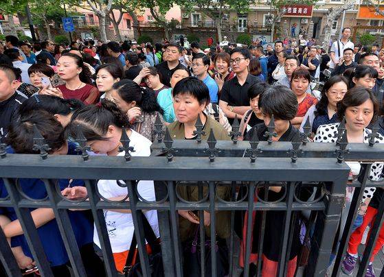 수험생을 시험장으로 보낸 학부모들의 마음은 어디든지 똑같은 듯 하다. 7일 칭다오의 한 고사장 밖에서 가족들이 초조한 표정으로 첫날 시험종료를 기다리고 있다.[AFP=연합뉴스]